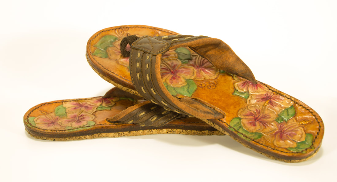 Leather flip-flops with hibiscus flowers tooled design.